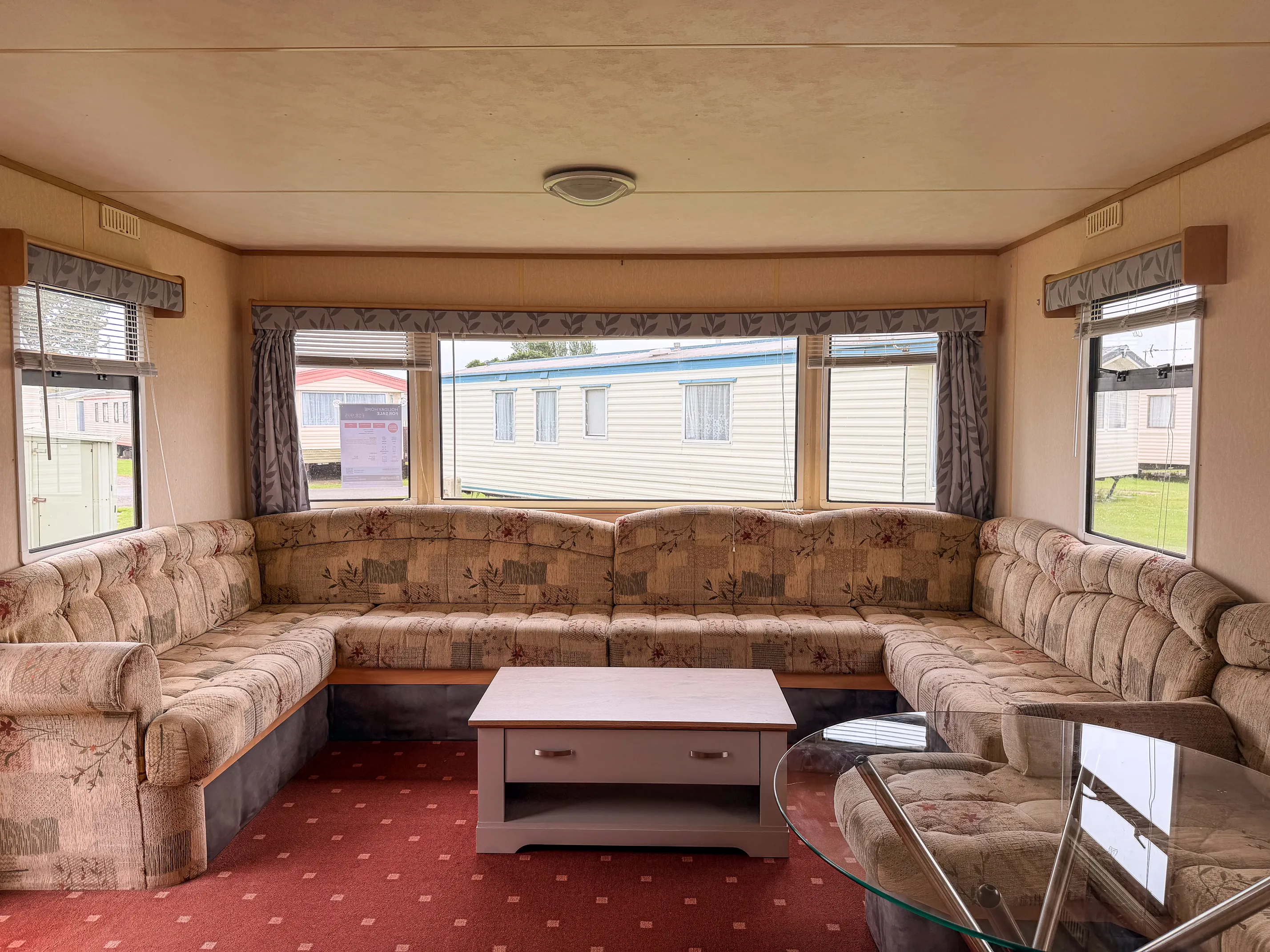 ABI Colorado Caravan interior of living room with bench seating, large windows and a coffee table