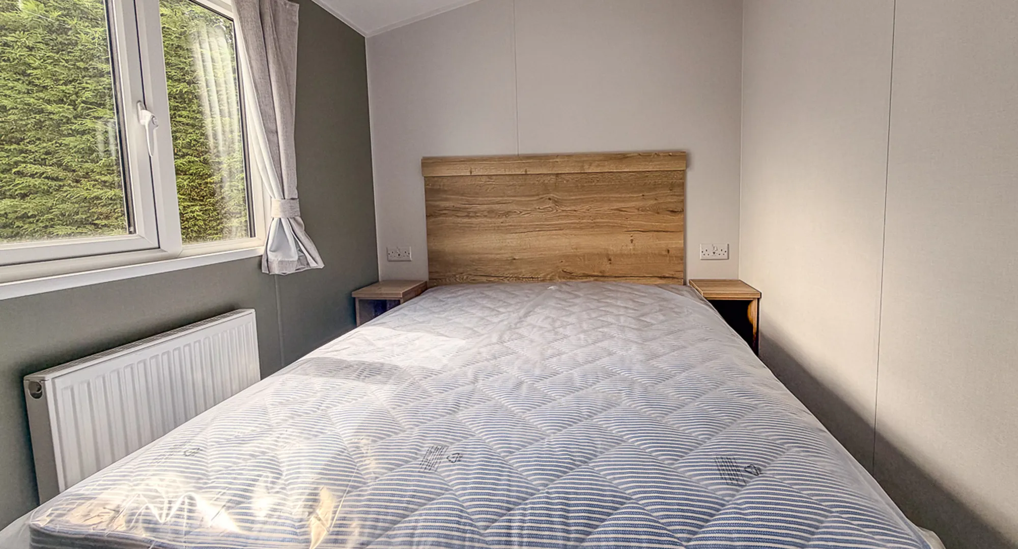 Master bedroom with large bed, night tables and wooden headboard