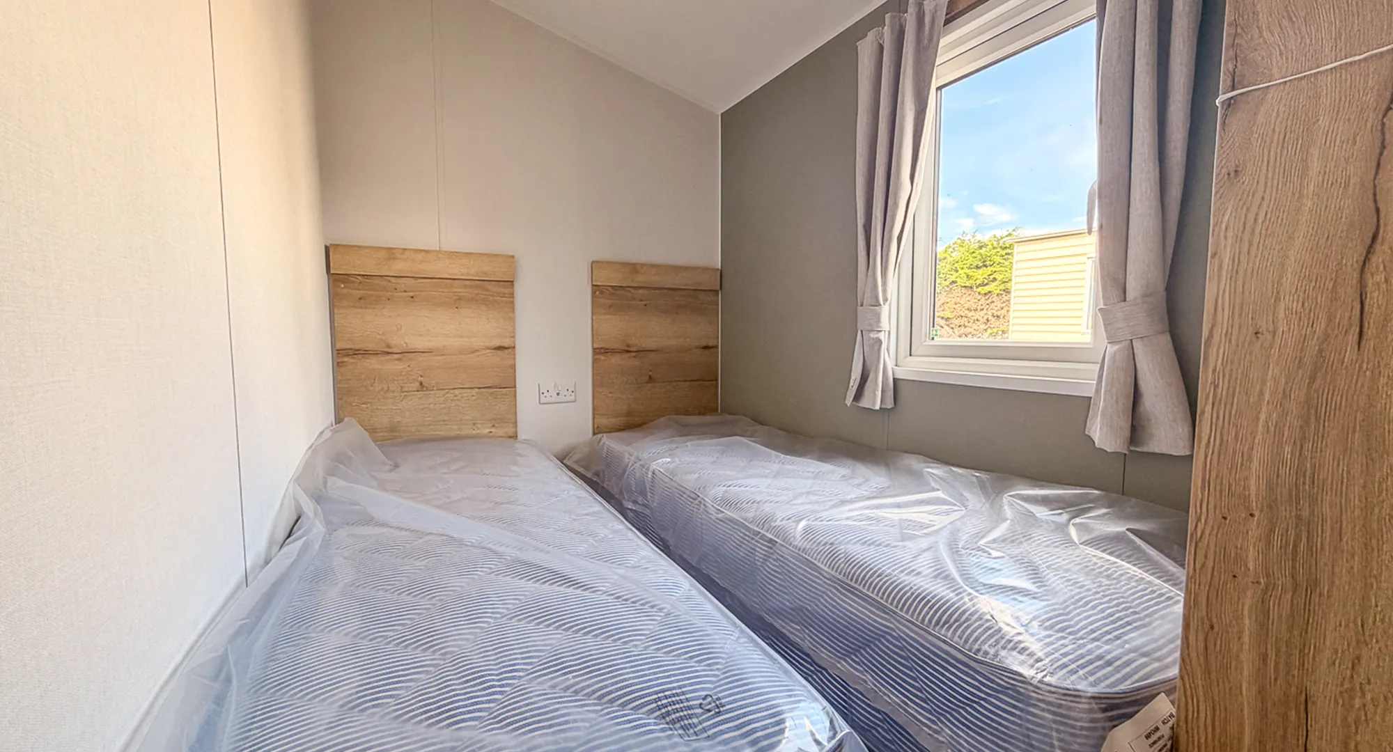 bedroom with two single beds, night stand in between them and wooden headboards