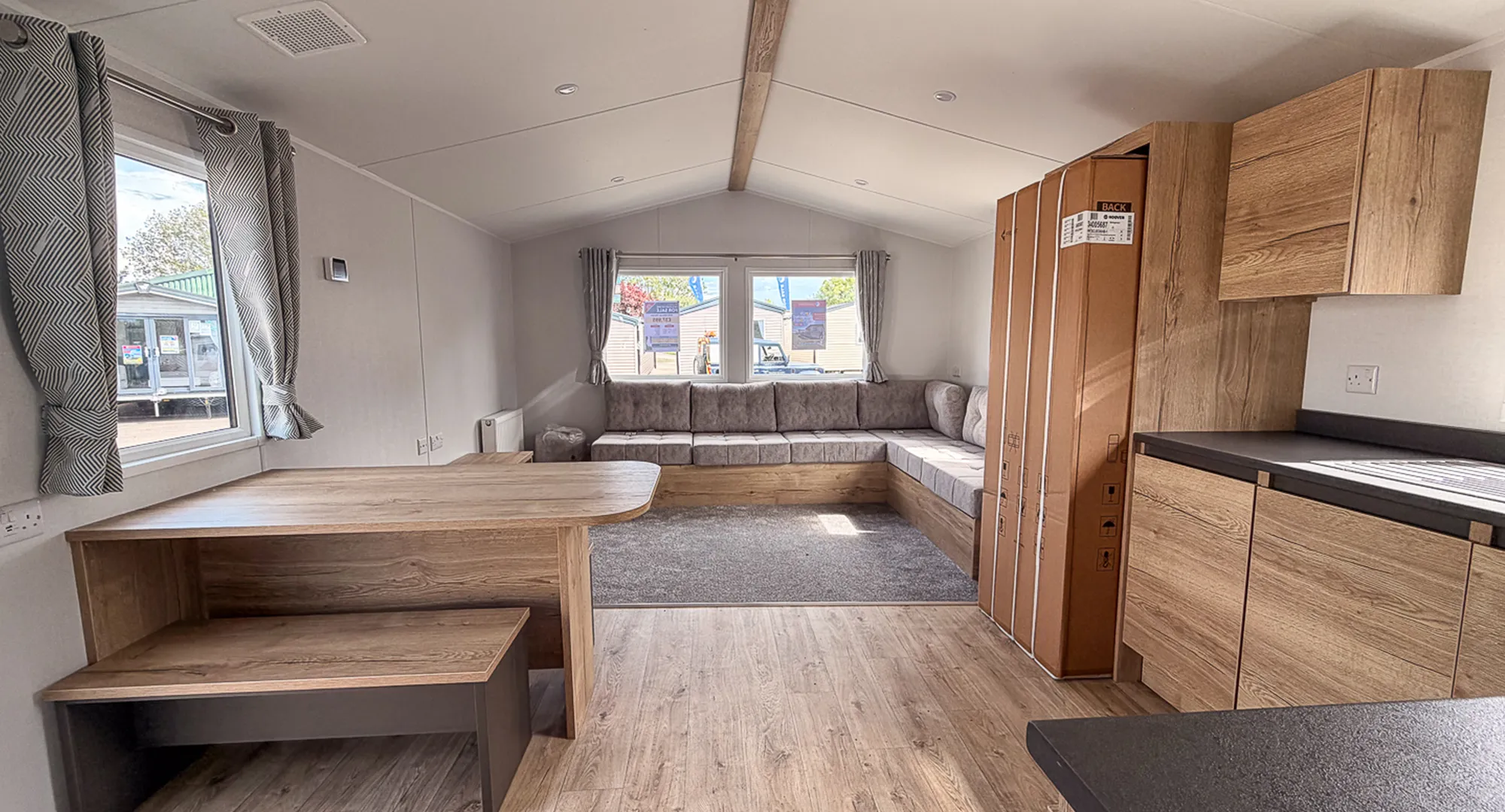 view of open plan kitchen, living and dining area with windows in the rear