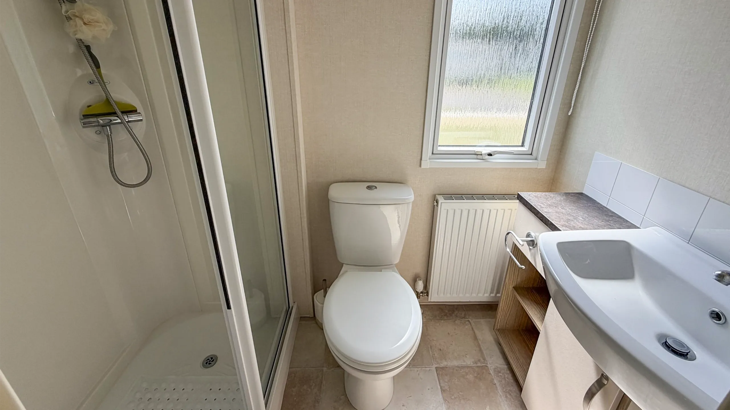 one of two bathrooms with built in shower, sink and toilet