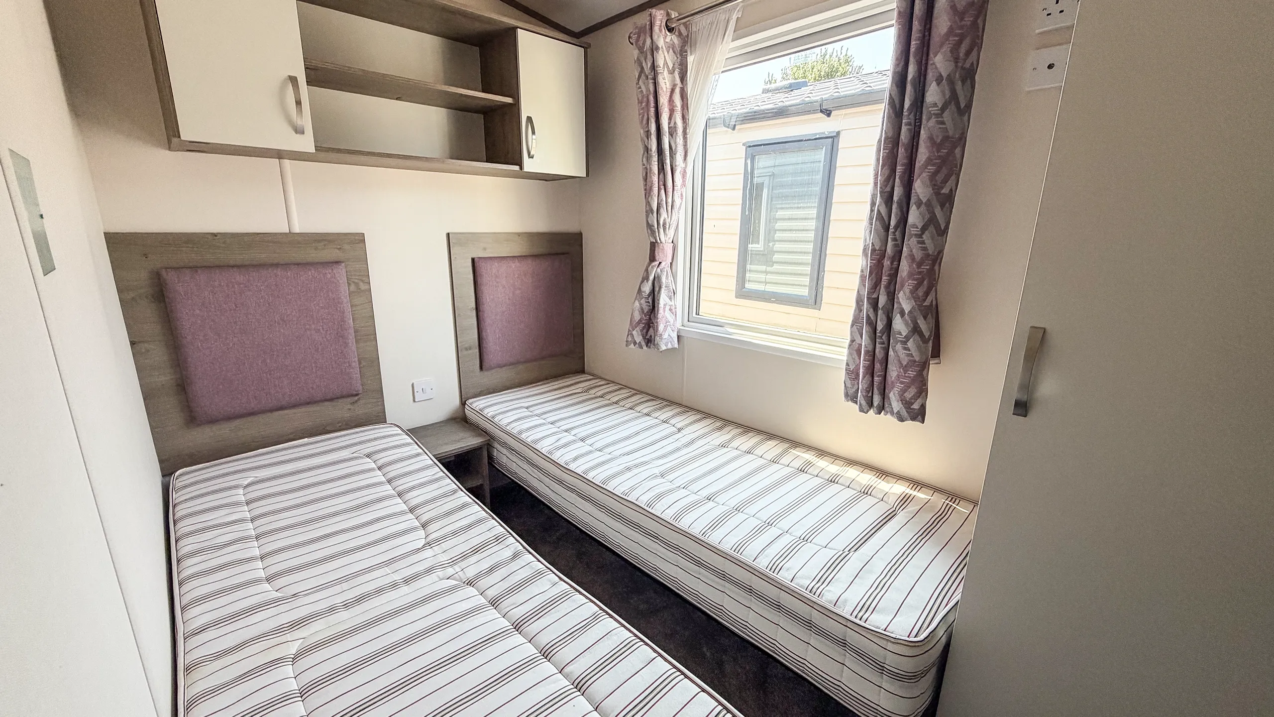 twin bedroom, with overhead storage and large window