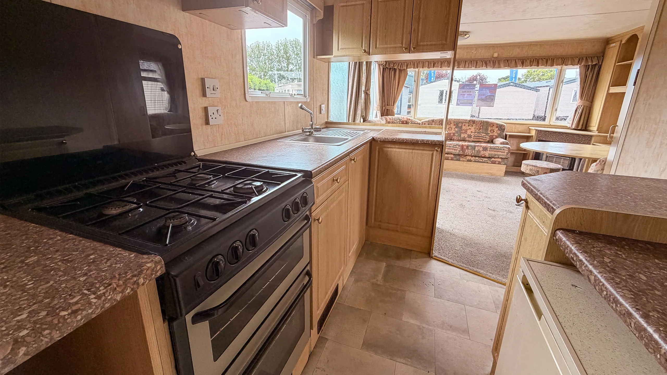 caravan interior kitchen cabinets with black cooker and sink