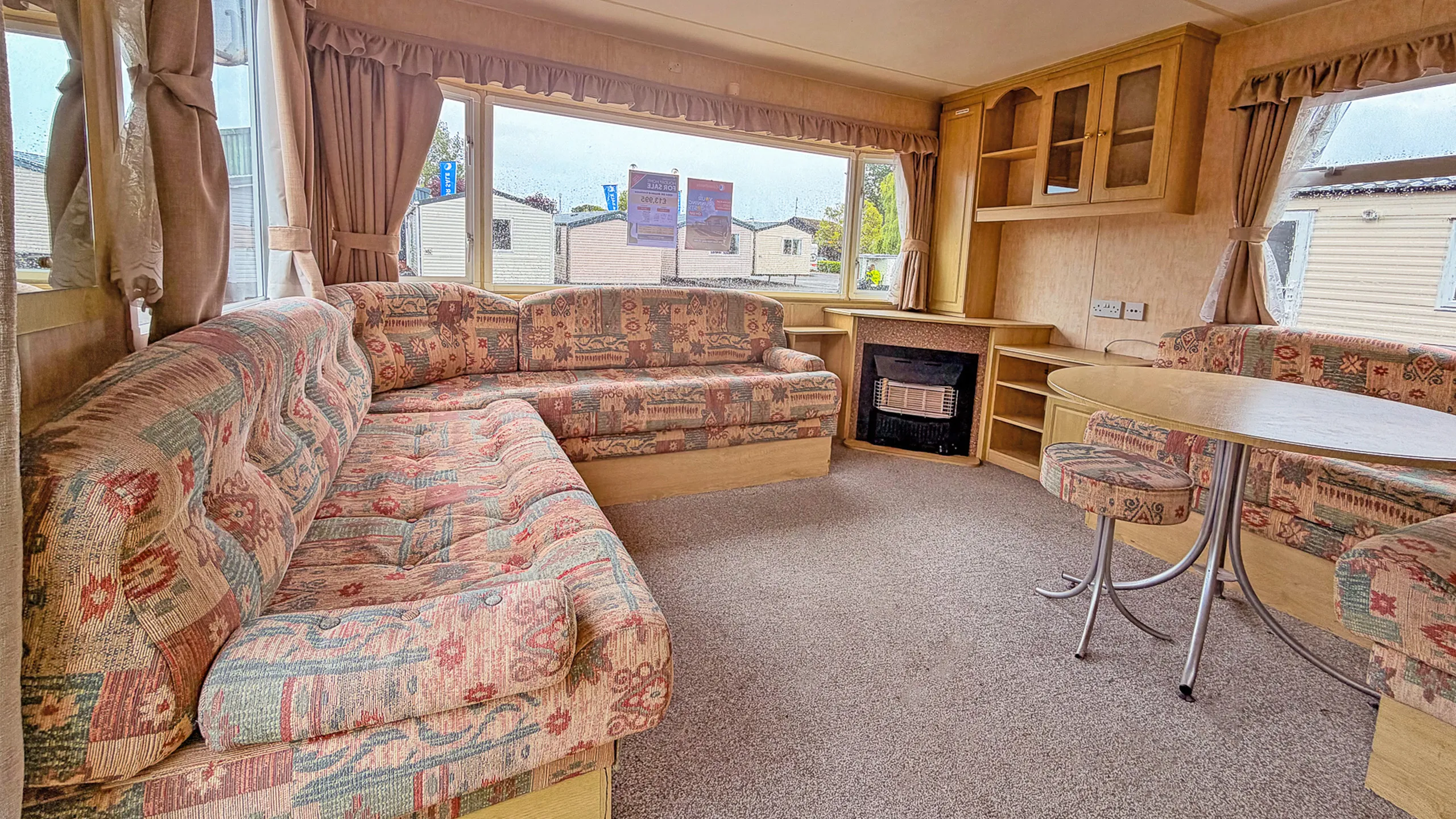 interior of living area of a holiday home with L-shaped sofa and fireplace
