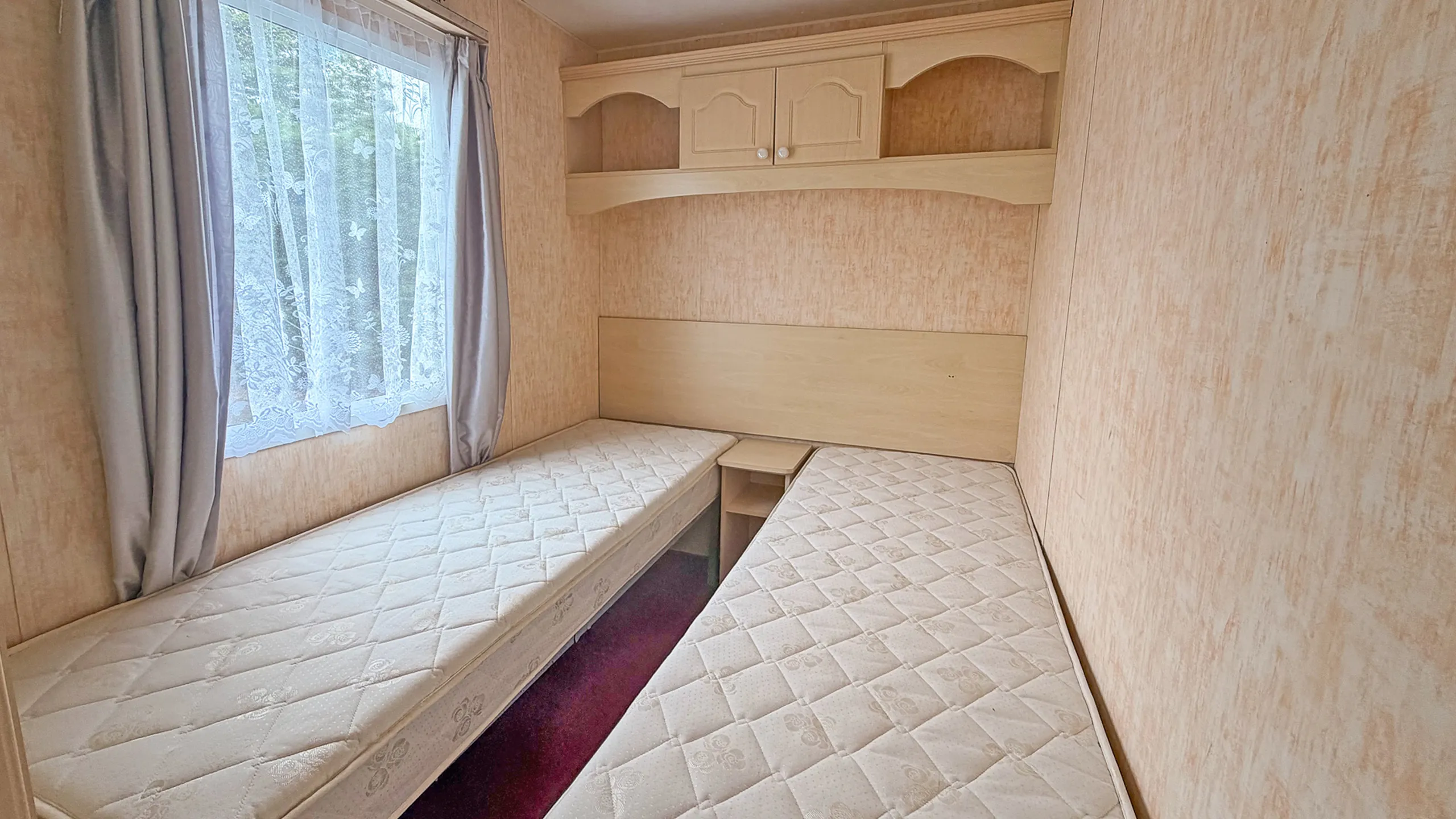 twin bedroom with two single beds inside a holiday home caravan