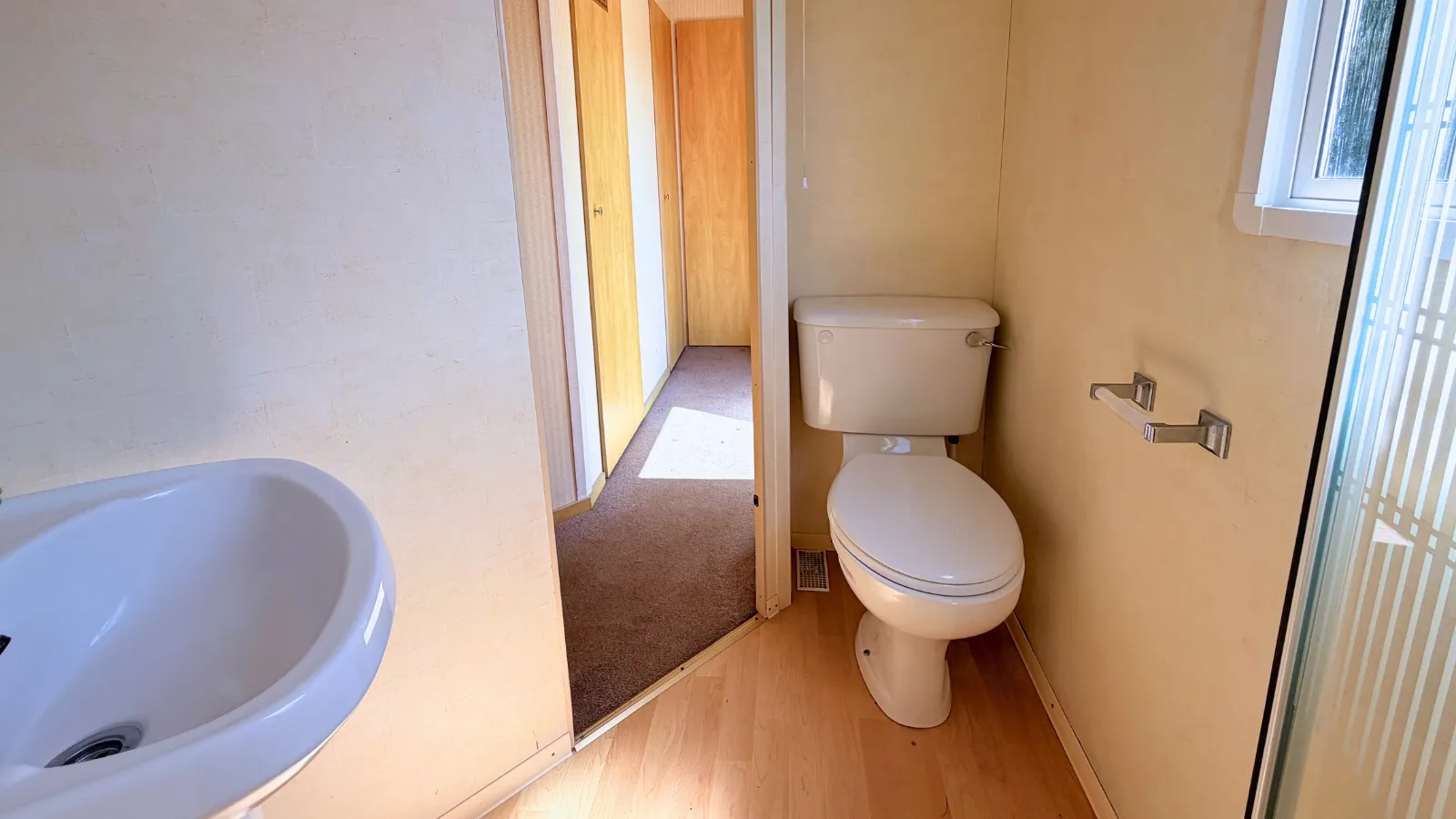 interior view of static caravan bathroom showing the exit door and a toilet