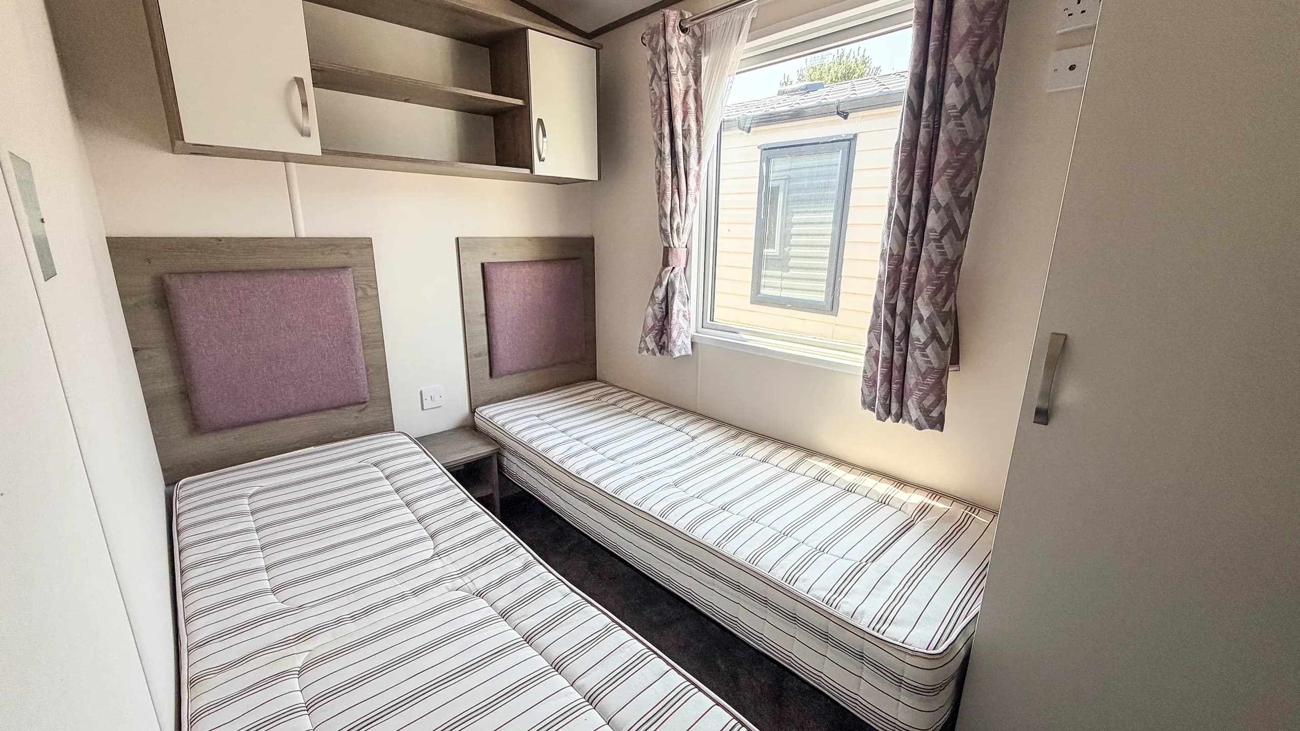twin bedroom, with overhead storage and large window