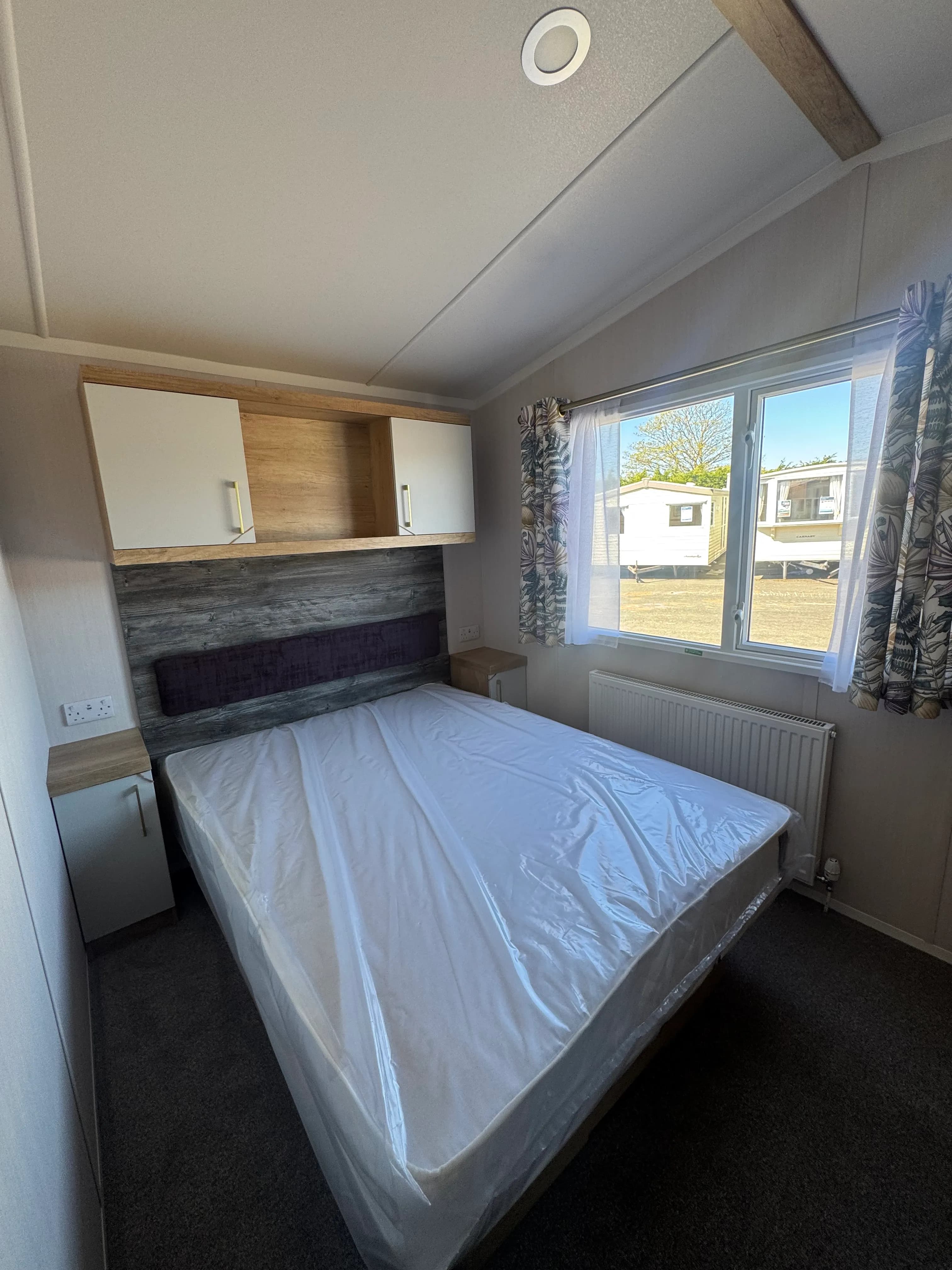Master bedroom with lift-up storage bed in the 2026 Swift Bordeaux