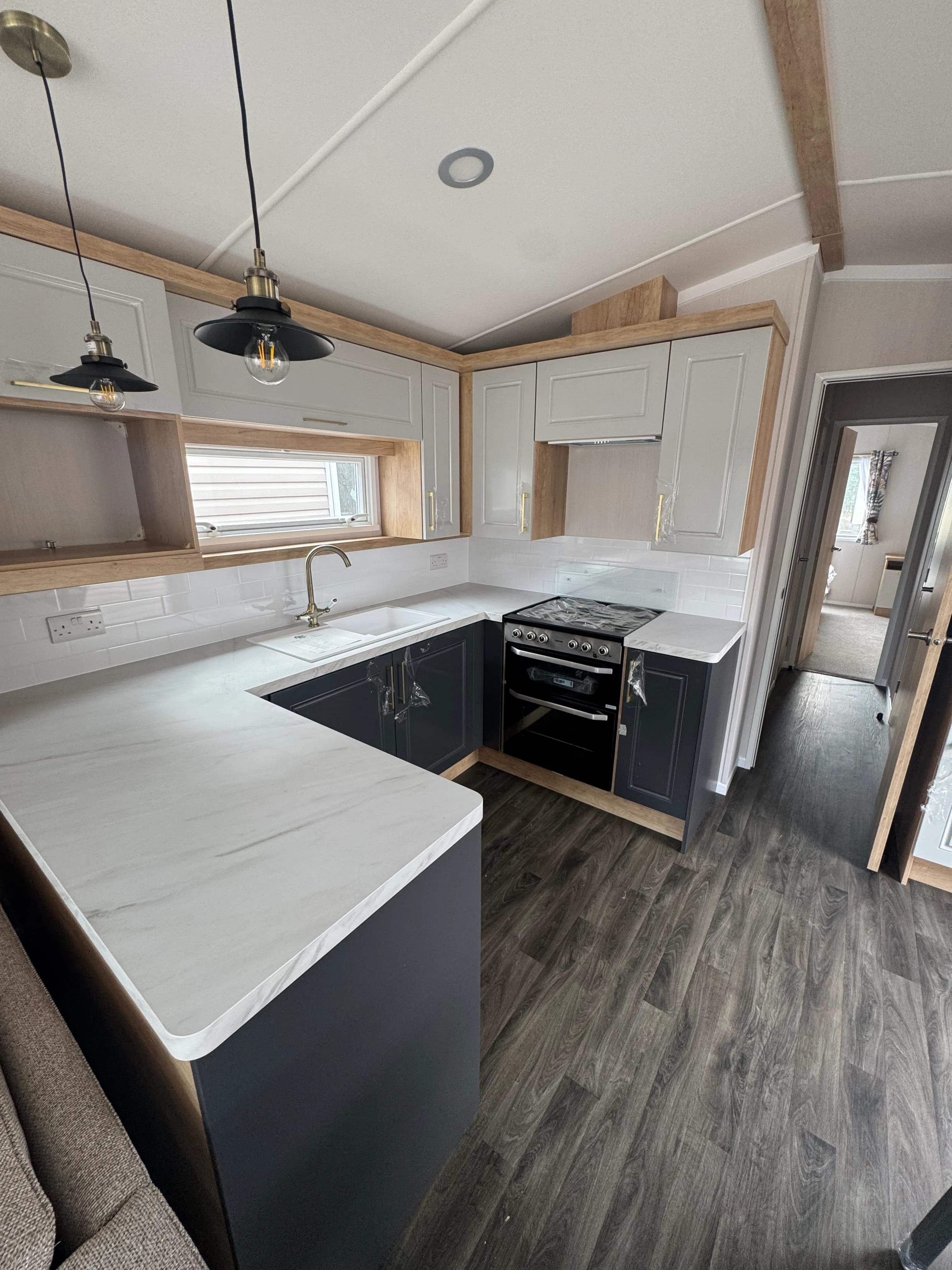 the kitchen area with dark cabinetry and white marble pattern countertops on a 2026 Swift Bordeaux for sale in Skegness at Coastfields Holiday park