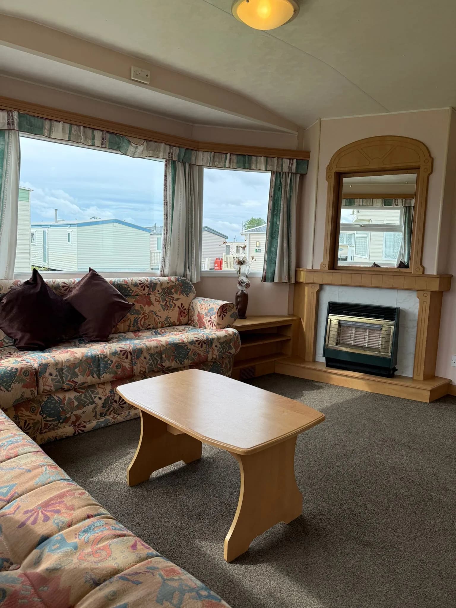 Living room of the 2002 Atlas Everglade with comfortable seating and bright windows