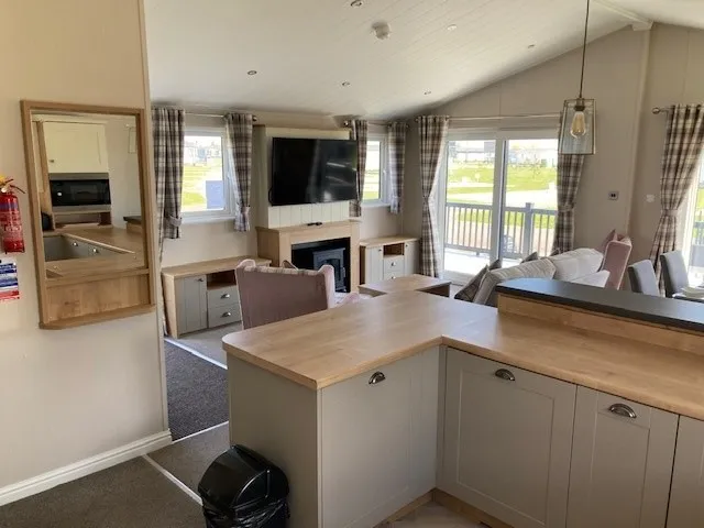 Luxury open-plan lounge with log-burner style electric fire in the 2023 Willerby Portland Lodge