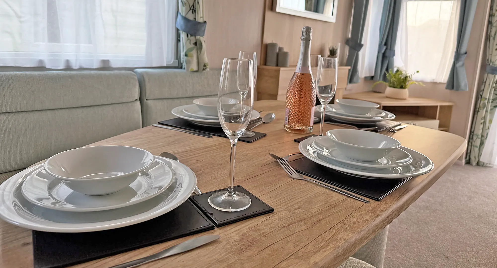 Swift Burgundy at Coastfields dining table set with plates, champagne and glasses