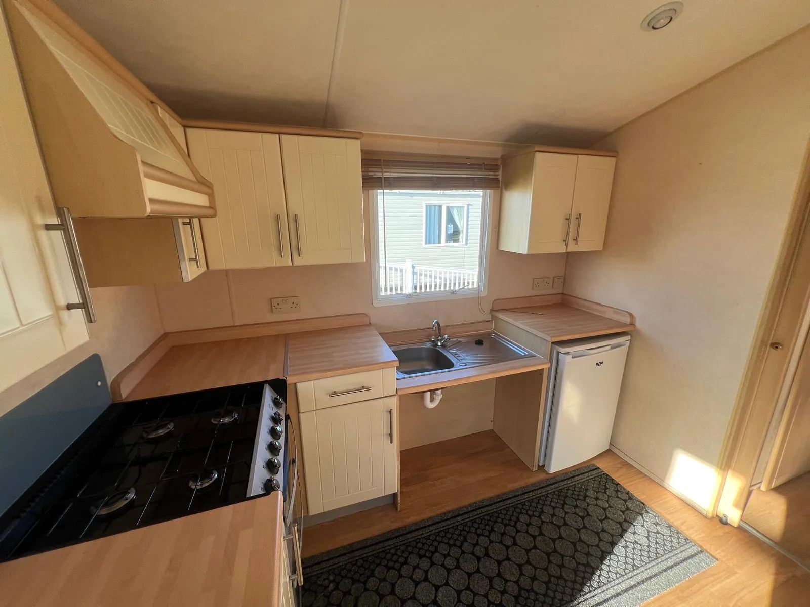 Interior view of a kitchen with light wood cabinets inside a static caravan