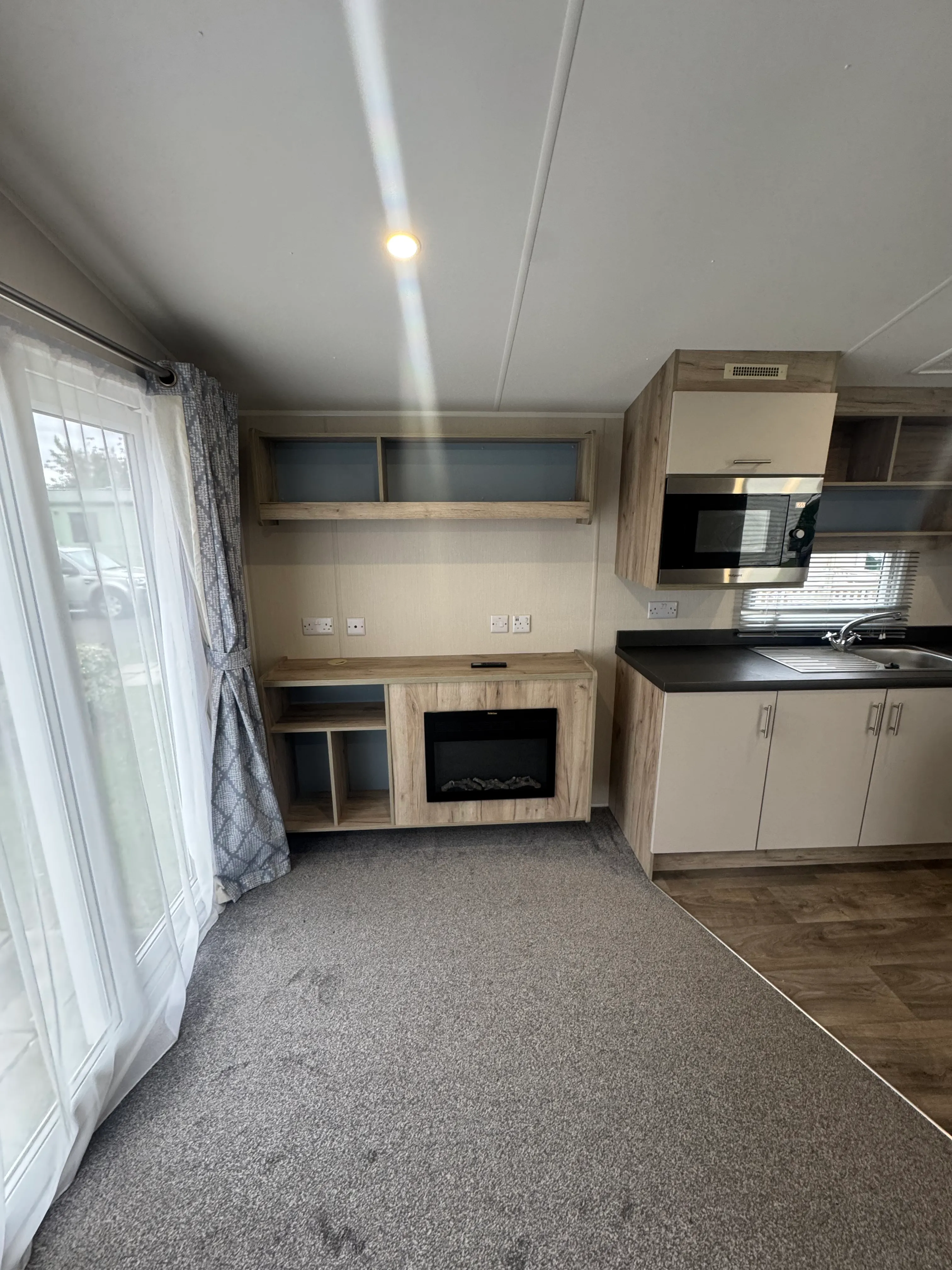 Willerby Linwood living area with fireplace and overhead shelfing with space for a tv
