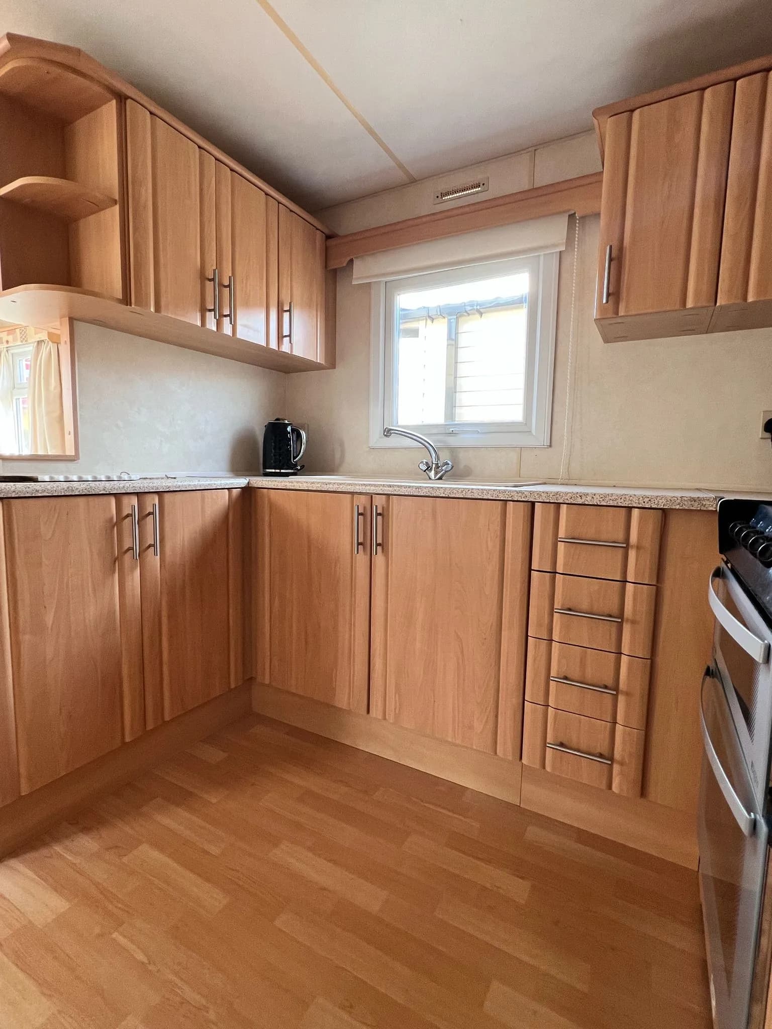 kitchen area on 2008 ABI Colorado with lower and upper cabinets, a window and sink