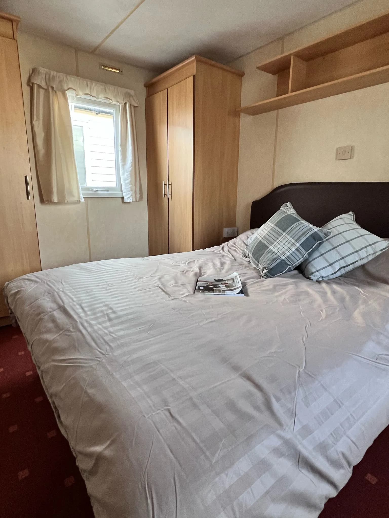 Main bedroom with double bed, wardrobe at the side and overhead shelving