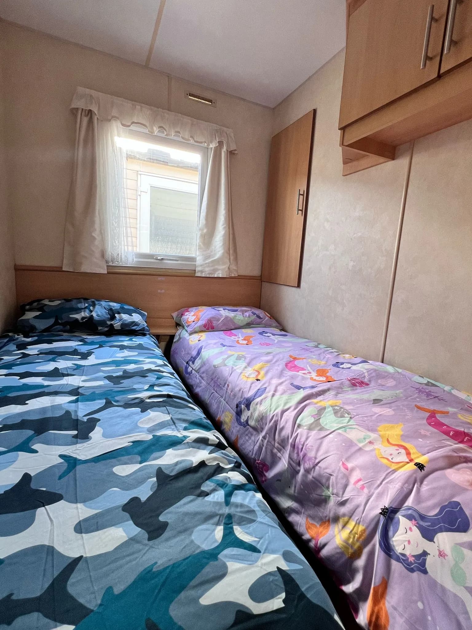 secondary bedroom on 2008 ABI Colarado with two twin beds and overhead cupboards