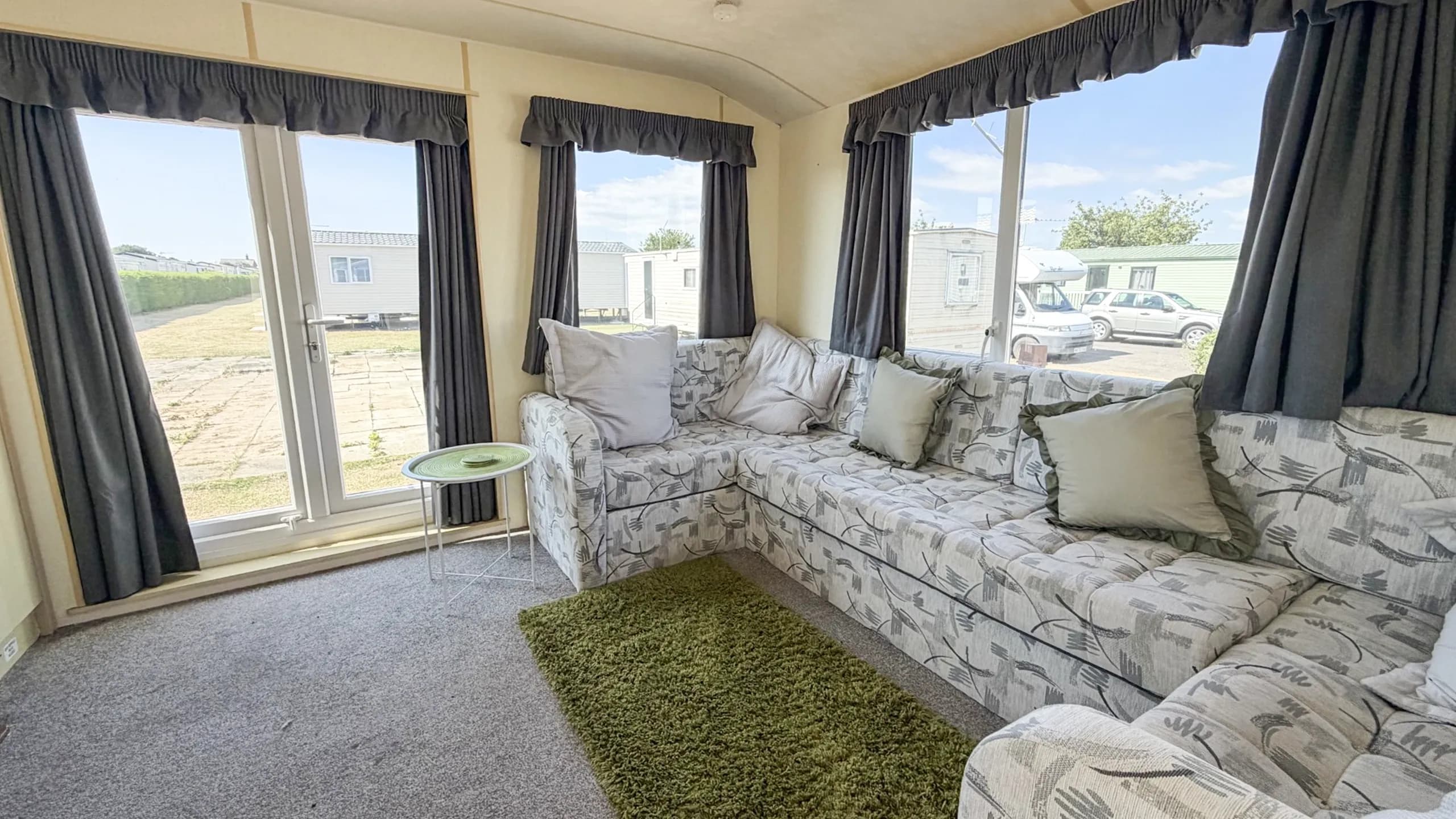 Spacious lounge inside the 2007 Atlas Lakeland Super holiday home with comfortable family seating.