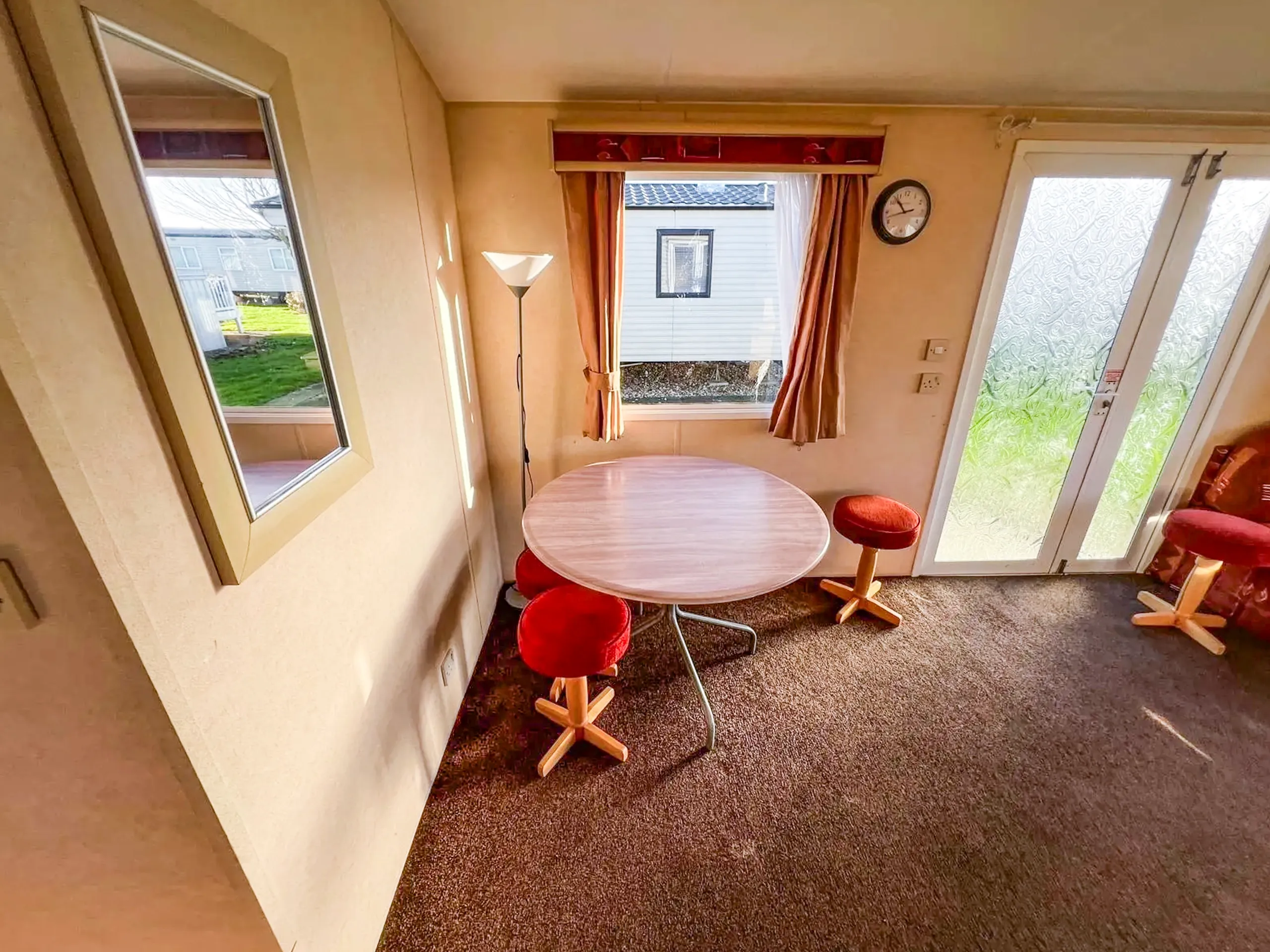 interior dining room inside a static caravan showing a wooden dining table next to a window