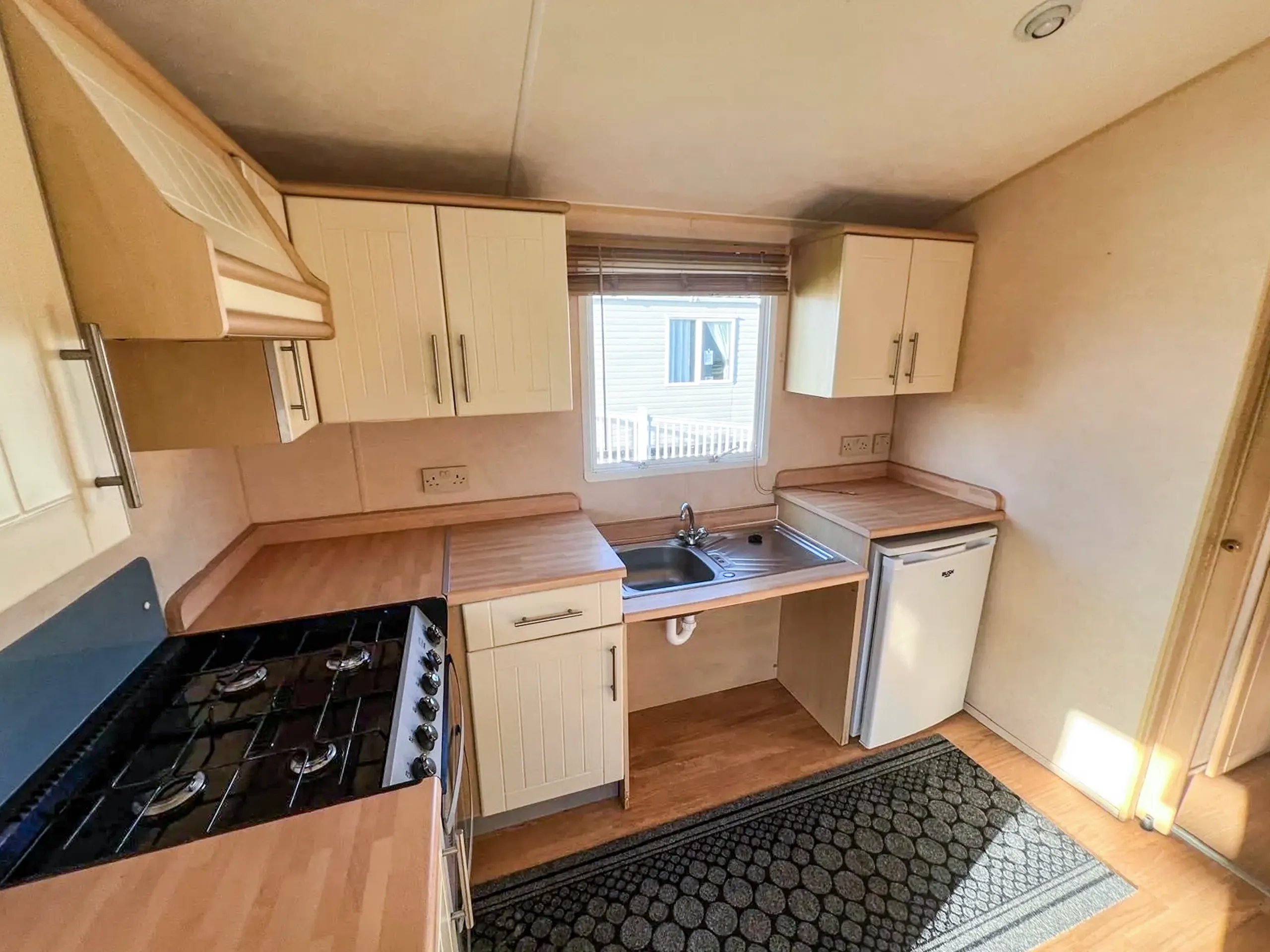 Interior view of a kitchen with light wood cabinets inside a static caravan
