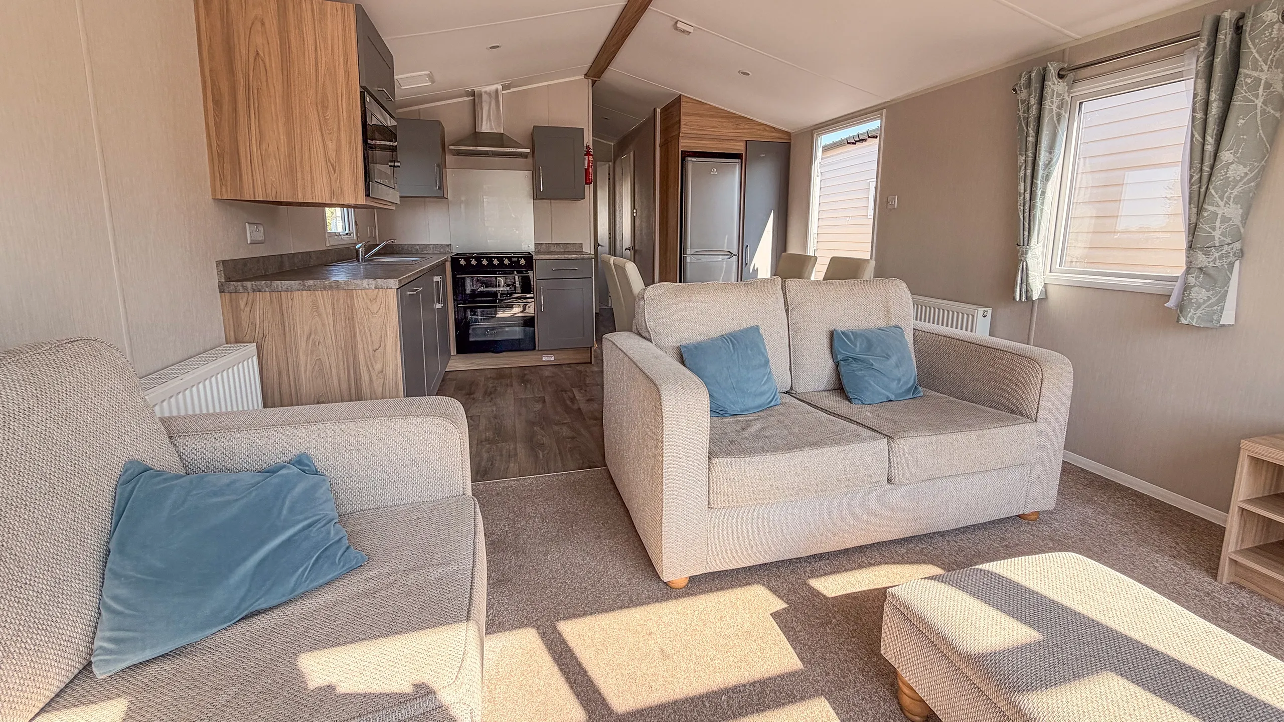 Living room of the 2021 willerby malton with comfortable seating and large windows