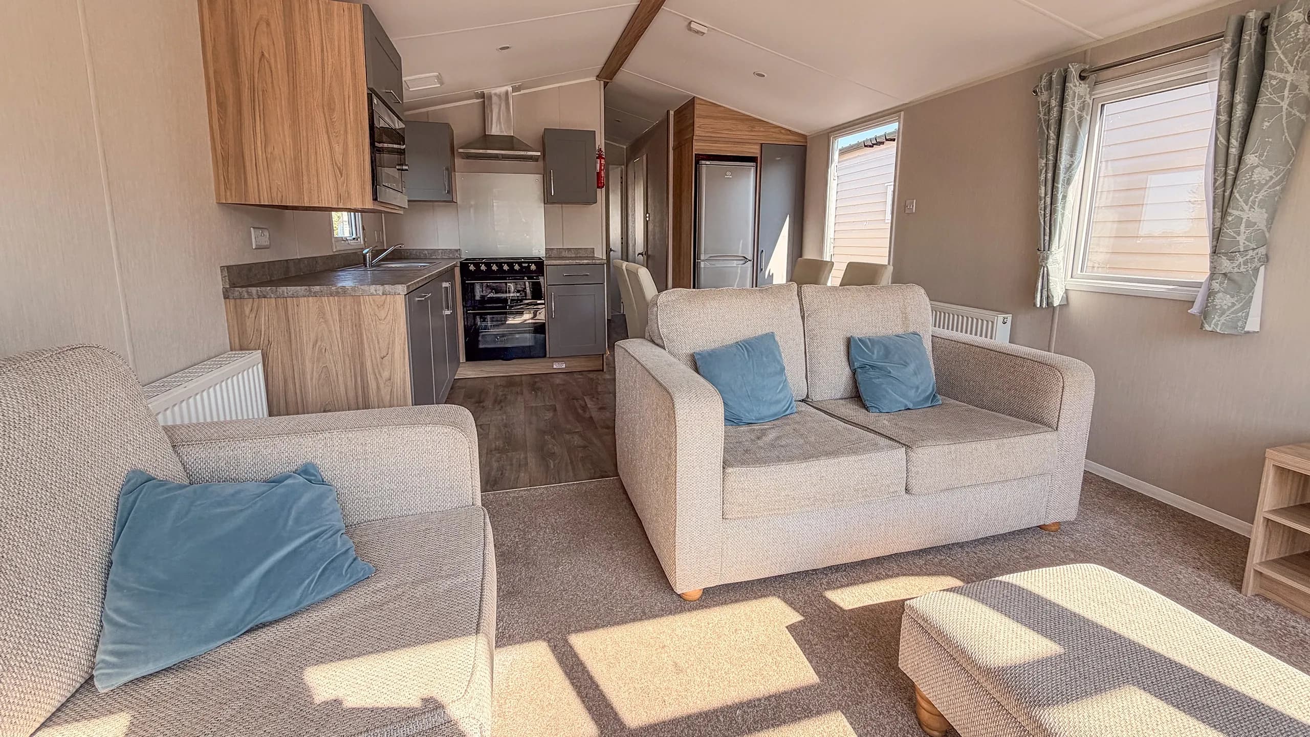 Living room of the 2021 willerby malton with comfortable seating and large windows
