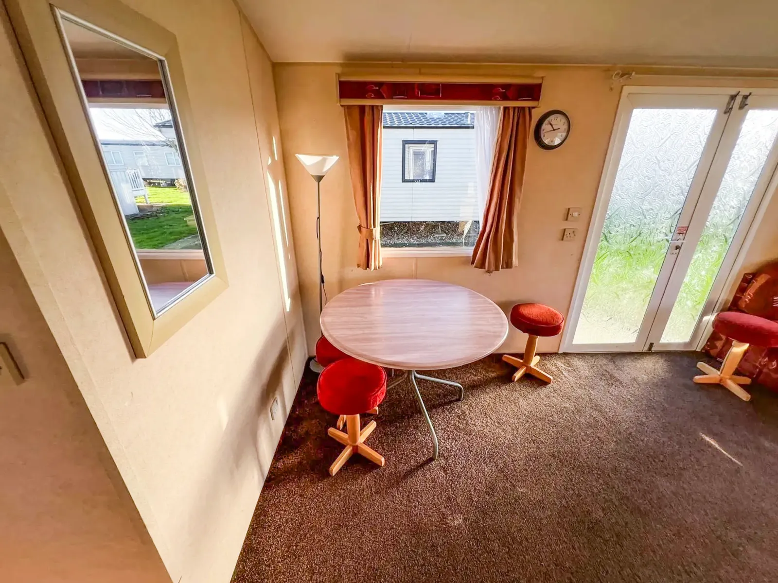interior dining room inside a static caravan showing a wooden dining table next to a window