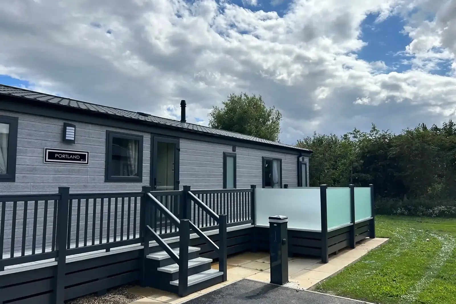 Exterior of the 2023 Willerby Portland Lodge with raised decking and steps at Grange Leisure Park