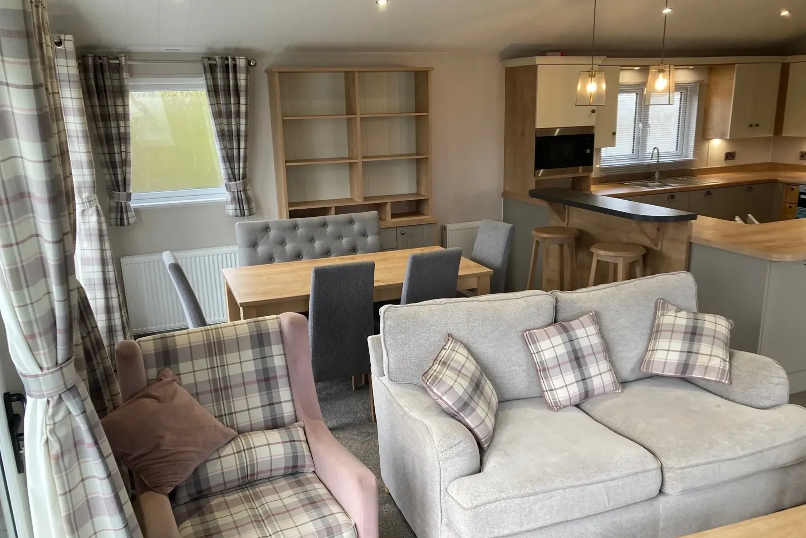 Spacious open-plan living area with kitchen island, lounge and dining space in the Willerby Portland Lodge