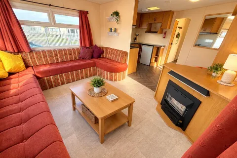 Spacious lounge with wraparound seating and feature fireplace in the 2002 Cosalt Torbay at Coastfields Holiday Village