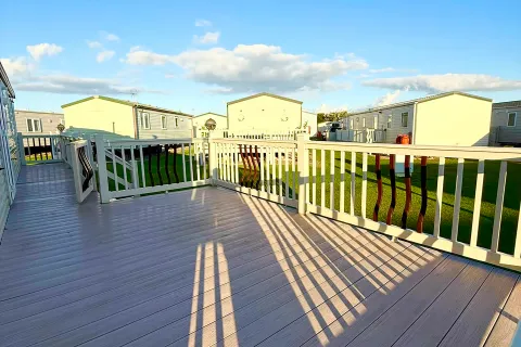 Outdoor decking with seating and views across Coastfields Holiday Village in Ingoldmells