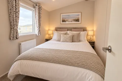 Stylish main double bedroom with neutral bedding and bedside lighting in the 2026 Willerby Malton holiday home