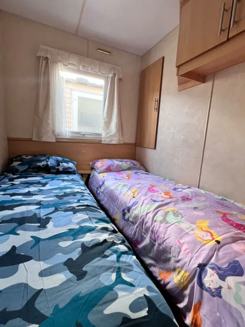 secondary bedroom on 2008 ABI Colarado with two twin beds and overhead cupboards