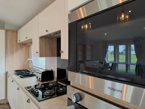 Modern kitchen with integrated appliances in the 2022 Willerby Pinehurst Lodge